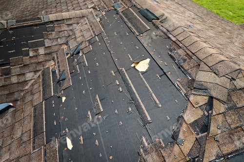 Preview: Damaged house roof with missing shingles after hurricane Ian in Florida.