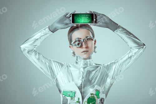 Preview: silver robot holding smartphone with appliance above head isolated on grey, future technology