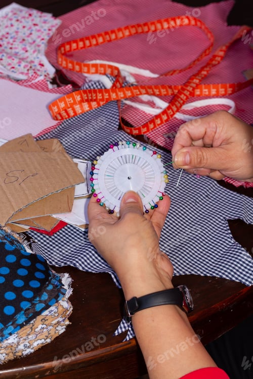 Preview: Vertical shot of a seamstress making various cloth masks - a new normal concept
