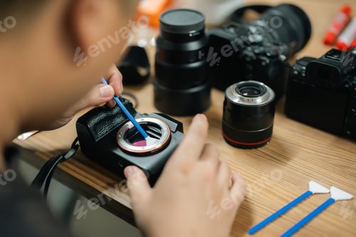Preview: Precision at Work: Camera Technician Expertly Cleans Sensor for Photography Equipment Performance