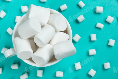 Preview: marshmallow laid out on blue paper background. pastel creative textured pattern