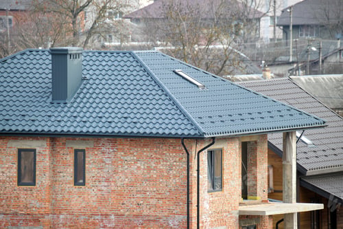 Preview: Aerial view of house roof top covered with ceramic shingles. Tiled covering of building under