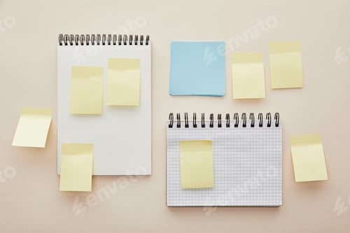 Preview: top view of blank sticky notes on notebooks isolated on beige