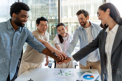 Preview: Diverse Business Team Joining Hands in Modern Office, Celebrating Success and Teamwork