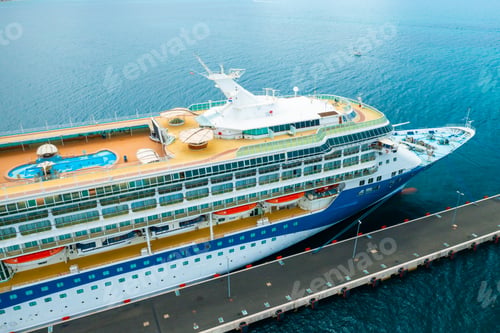 Preview: Aerial view of a luxury cruise ship or linear with a swimming pool on the roof moored in marina