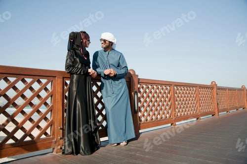 Preview: Couple engaging in a warm conversation on a bridge