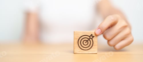Preview: hand hold dartboard block with business goal, strategy,