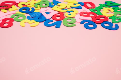 Preview: Closeup shot of colorful wooden numbers scattered on a pink surface - space for text