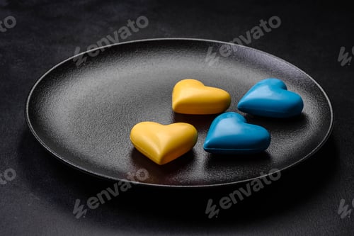 Preview: Chocolate hearts in the colors of the Ukrainian flag on a black ceramic plate