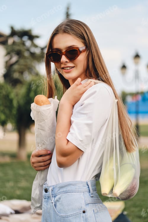 Preview: Stylish Woman Holding Bread in a City Park