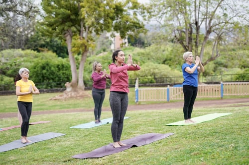 Preview: Multi generational people doing yoga exercise at city park