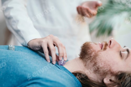 Preview: Crystal Therapy with Young Man Lying on Massage Table