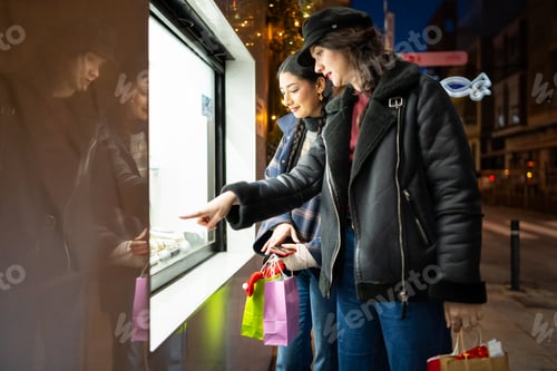 Preview: Women friends window shopping at christmas night