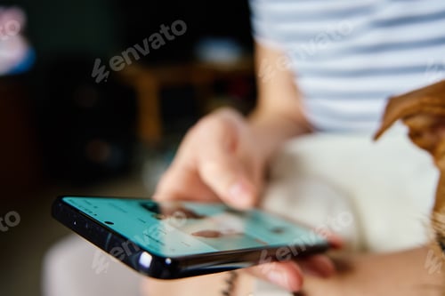 Preview: Woman using mobile phone at home