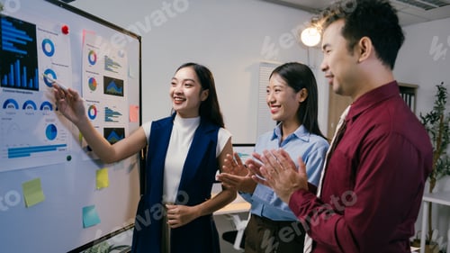 Preview: Asian businesswoman pointing at whiteboard with charts and graphs, illustrating positive results, wh