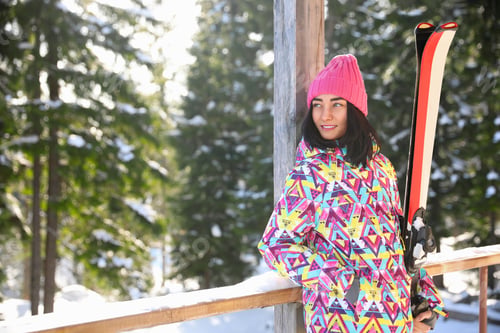 Preview: Young woman with ski wearing winter sport clothes in forest. Space for text