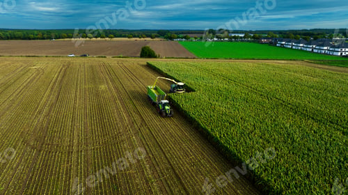 Preview: a big green machine is going over a green field with grass