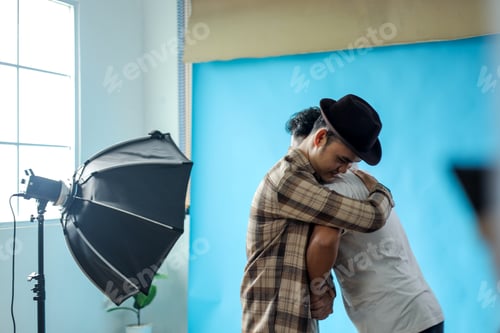 Preview: Two Men Embracing Warmly in Photography Studio Setting