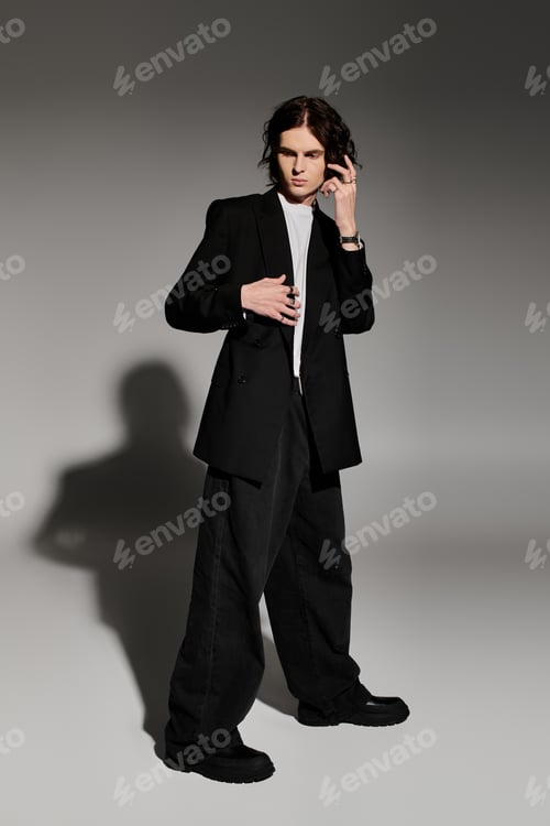 Preview: A handsome young man showcases his fashion sense in a sleek outfit, illuminated by soft shadows.