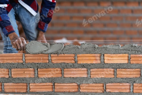 Preview: Closeup hand professional construction worker laying bricks in new industrial site.