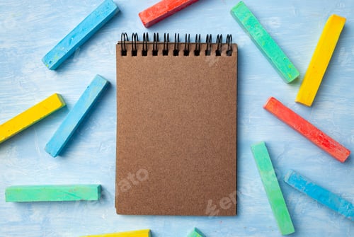 Preview: Colorful chalks on blue background with copy space for text