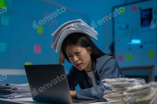 Preview: Stressed businesswoman works late, papers on head, struggling to meet deadline, feeling pressure and