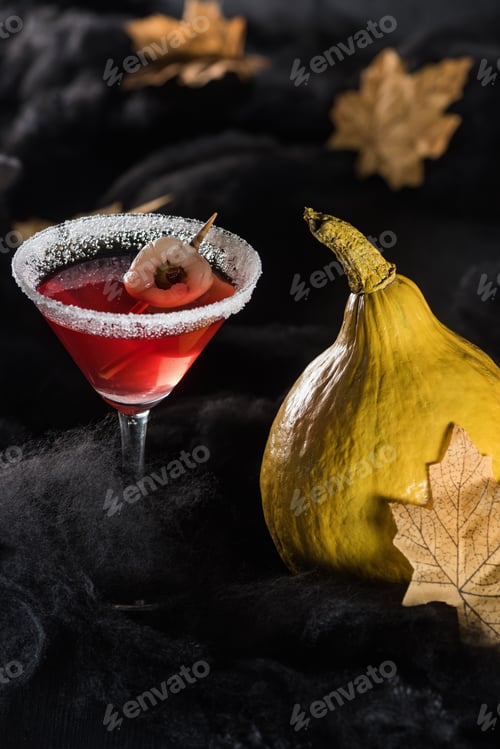 Preview: ripe pumpkins near cocktail and maple dry yellow leaves on black background
