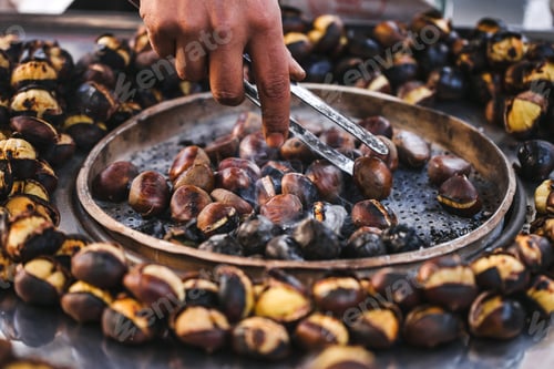 Preview: Man preparing roasted chestnuts, cooking outdoors. Street food in Istanbul