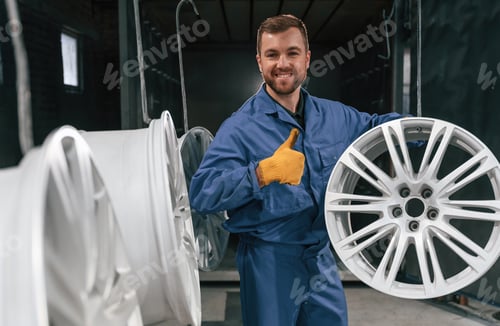 Preview: Showing thumb up. Car service station worker is taking care about disks of tires