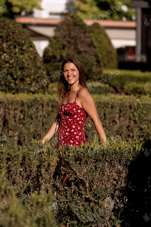 Preview: Woman smiling while enjoying walking outdoors in a park.