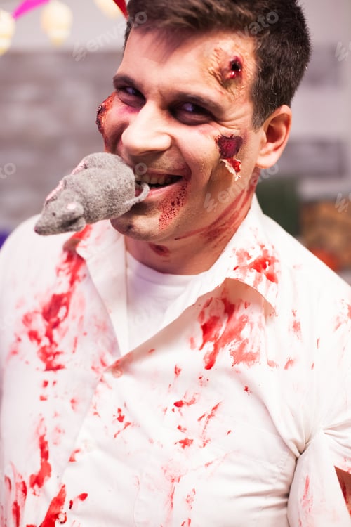 Preview: Man dressed up like a bloody zombie with a rat in his mouth