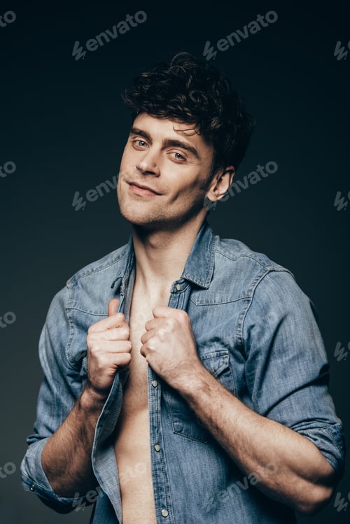 Preview: handsome smiling man posing in jeans clothes isolated on dark grey