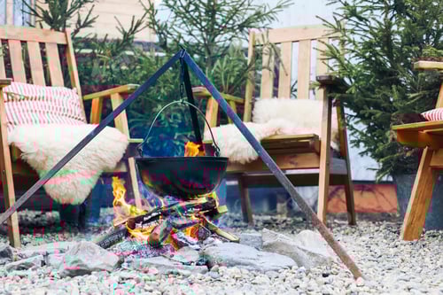 Preview: From above traditional mulled wine with slices of orange preparing in pot over burning logs