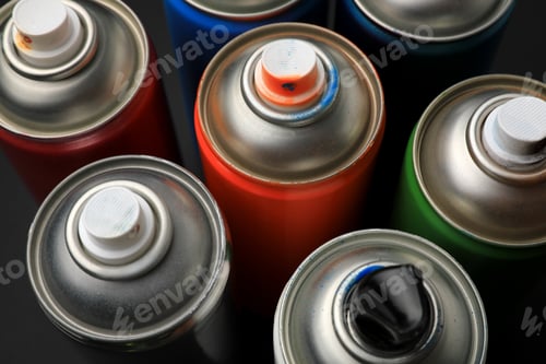 Preview: Cans of different graffiti spray paints on black background, closeup