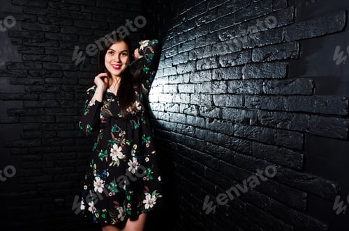 Preview: Portrait of a fabulous young woman in floral dress in the dark studio.