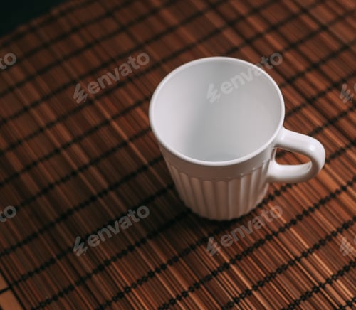 Preview: white mug on a wooden stand stands on the table top view