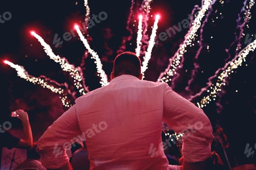 Preview: Celebrations around the world. A man from behind looking at the fireworks display.