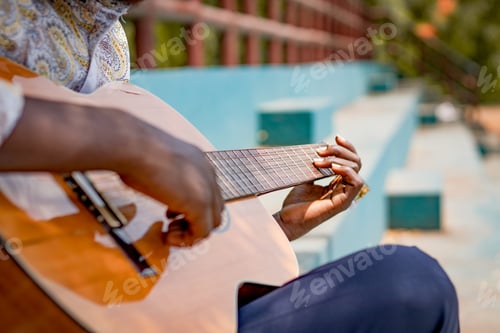 Preview: Man Playing Guitar Outdoors on Bright Day
