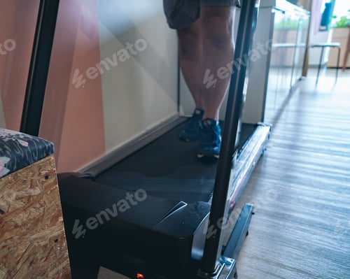 Preview: Man running in a gym on a treadmill concept for exercising, fitness and healthy lifestyle