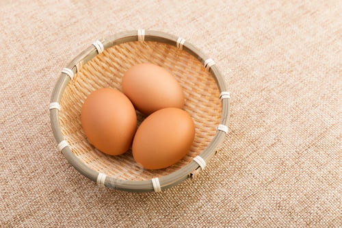 Preview: Egg in basket over linen background