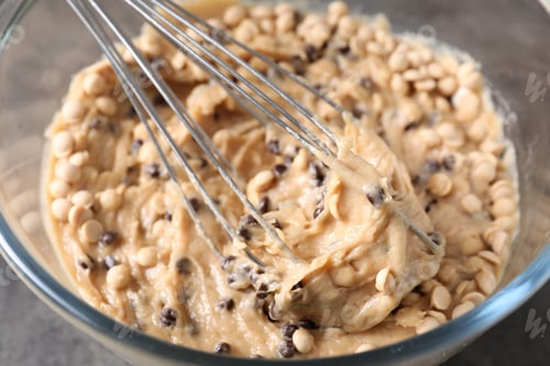 Preview: Raw dough with chocolate chips in bowl on grey table, closeup