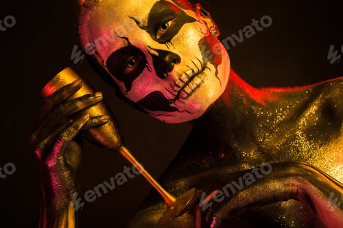 Preview: Pretty girl with skeleton makeup holds glass