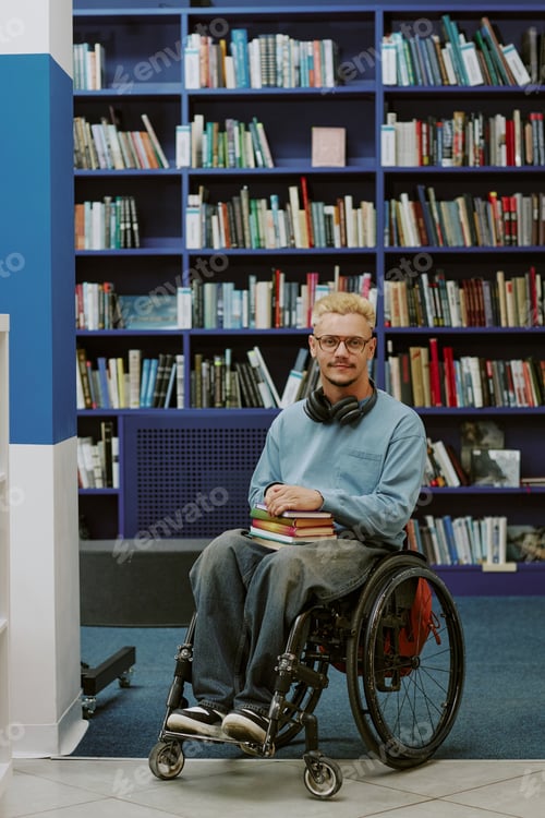 Preview: Man Using Wheelchair Holding Books in Library Setting