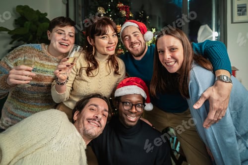 Visualização: Amigos usando chapéus de Papai Noel comemorando o Natal juntos em casa com champanhe - alegria de festa natalina