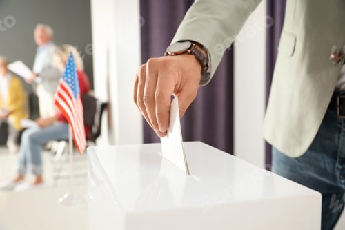 Preview: Man putting ballot paper into box at polling station, closeup