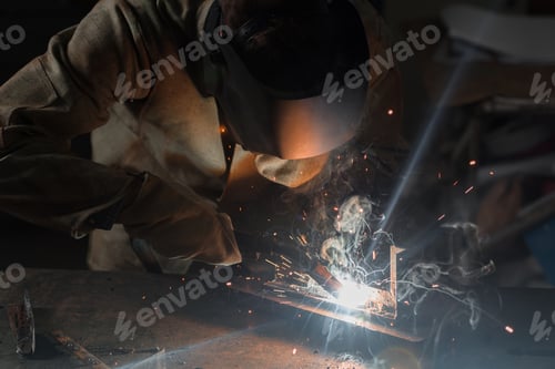 Preview: Manufacture Worker Welding Metal With Sparks at Factory