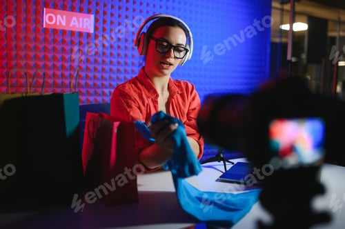 Preview: Young creative woman live streaming a video for her followers on social media