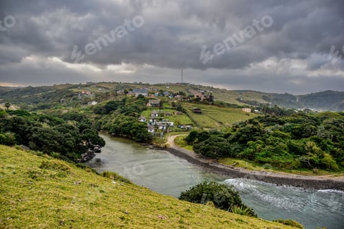 Preview: Scenic landscape featuring lush, green grass and a river flowing through a mountainous region