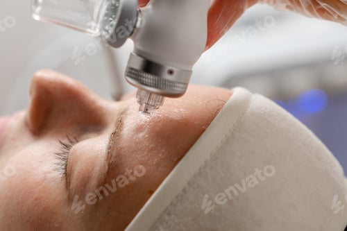 Preview: A beautician wearing gloves vacuum cleans and polishes the skin of a young woman's neck