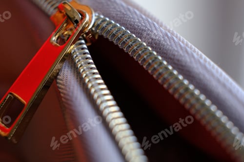 Preview: Selective focus, yellow metal zipper of a makeup bag or small purse macro pattern background